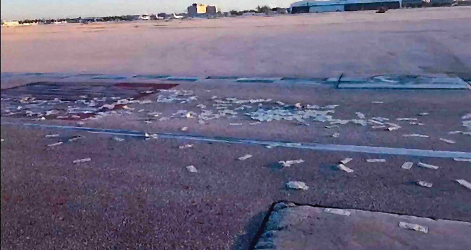 Loose banknotes scattered across the ramp roadway at dawn